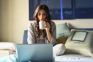 A lady enjoying her coffee while working at home